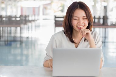 Dizüstü bilgisayar kullanan Asyalı kadın.