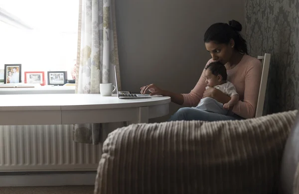 Moeder multi-tasking werk en baby — Stockfoto