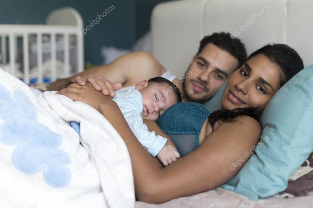 Family snuggles in bed