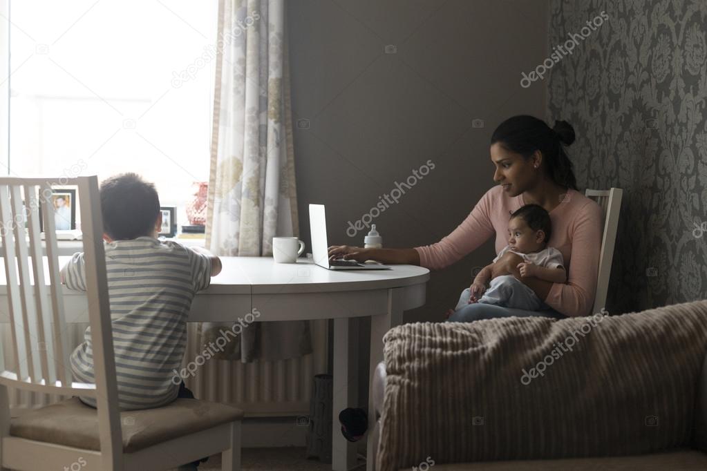 Mother multi-tasking work and children