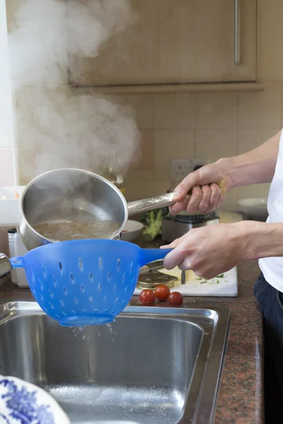 Menyaring air dari spageti yang dimasak — Stok Foto