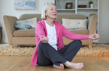 Yaşlı kadın evde meditasyon
