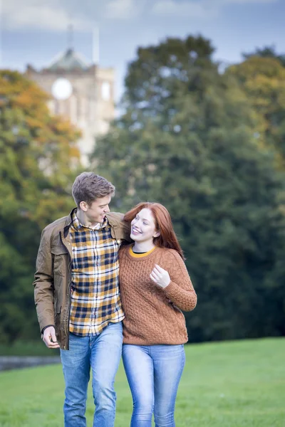 Young couple walking through a park — Stock Photo, Image