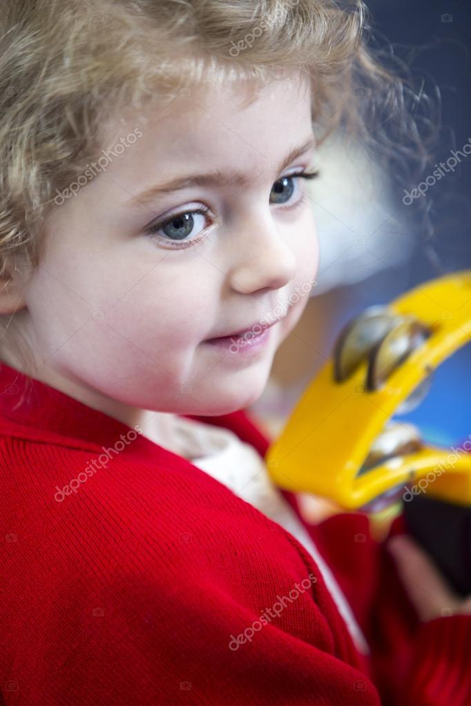 Girl Playing Tambourine at Nursery — Stock Photo © DGLimages 115193062
