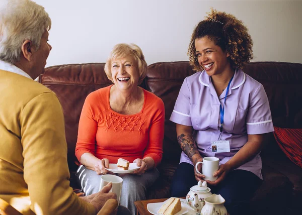 Pflegekraft teilt Teezeit mit ihren Patienten — Stockfoto
