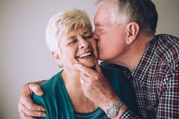 Senior Mann küsst Ehefrau auf Wange — Stockfoto