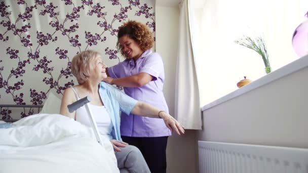 Altenpfleger kleidet Senioren ein — Stockvideo