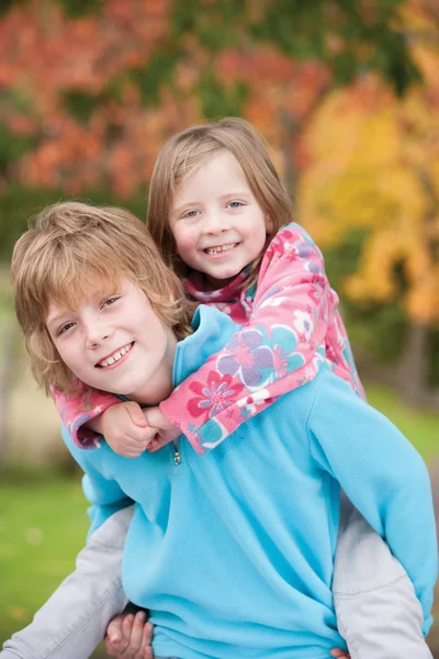 Bruder gibt Schwester Huckepack zurück — Stockfoto