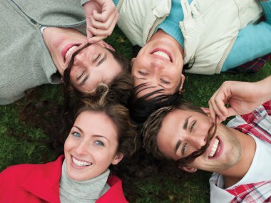 Four friends pose for the camera whilst lying toogether
