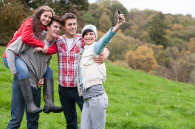 Four friends taking a selfie outdoors