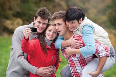 Four friends taking a selfie outdoors