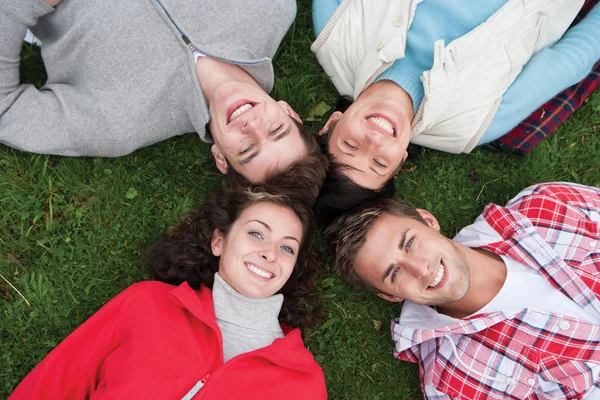 Four friends lying on the grass — Φωτογραφία Αρχείου