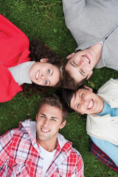 Four friends lying on the grass — Φωτογραφία Αρχείου
