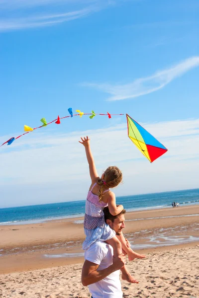 Vater und Tochter mit Drachen am Strand — Stockfoto