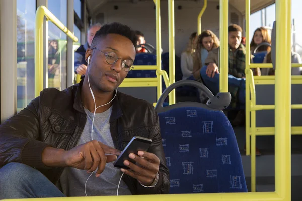 A fiatalember egy okostelefon segítségével a buszon — Stock Fotó
