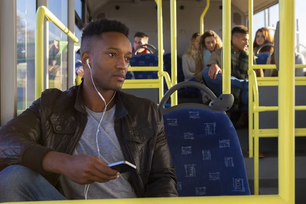 Young man using a smartphone on the bus — Stock Photo, Image