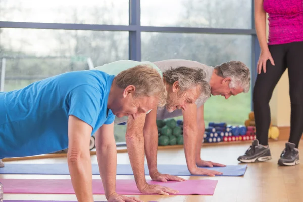 Tres hombres haciendo flexiones en el gimnasio — Foto de Stock