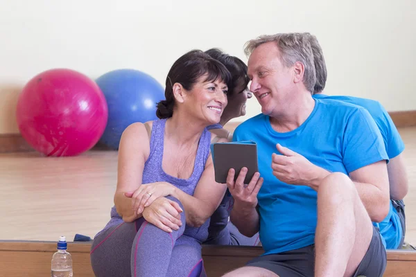 Personas mayores que utilizan la tecnología en el gimnasio —  Fotos de Stock