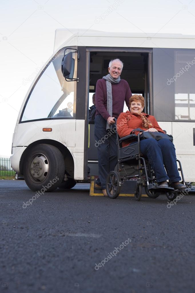 Elderly couple getting off their community bus