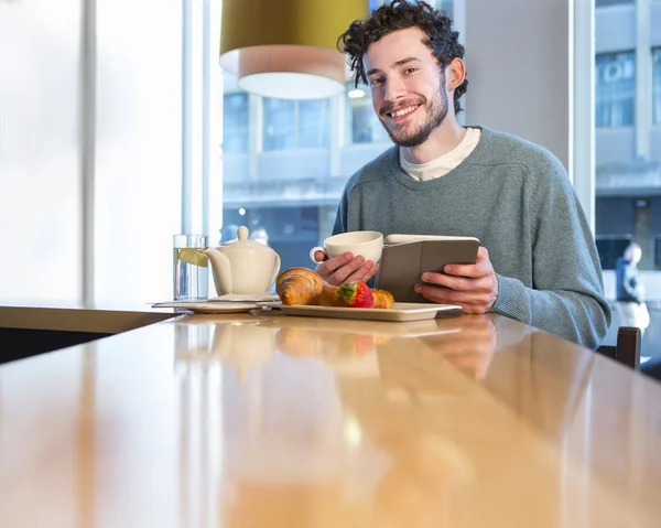 Jovem tomando café da manhã — Fotografia de Stock