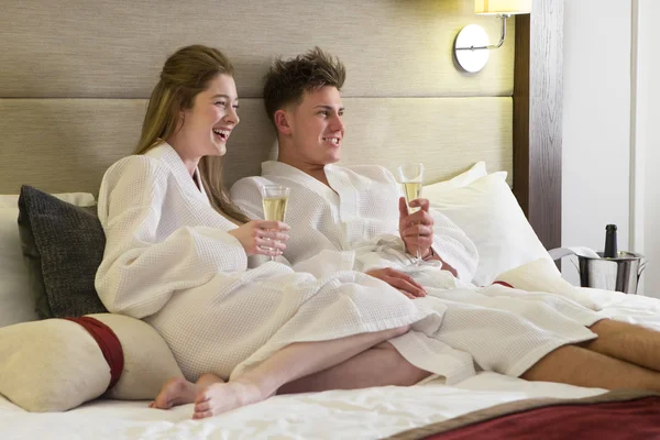 Pareja disfrutando de una copa en la habitación del hotel —  Fotos de Stock