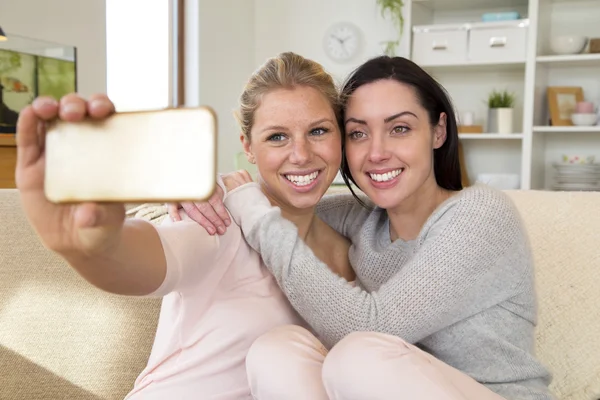 Női pár vesz egy selfie, a mobiltelefon használata — Stock Fotó