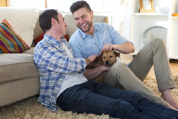 Чоловіча пара сидить зі своїм домашнім собакою — стокове фото