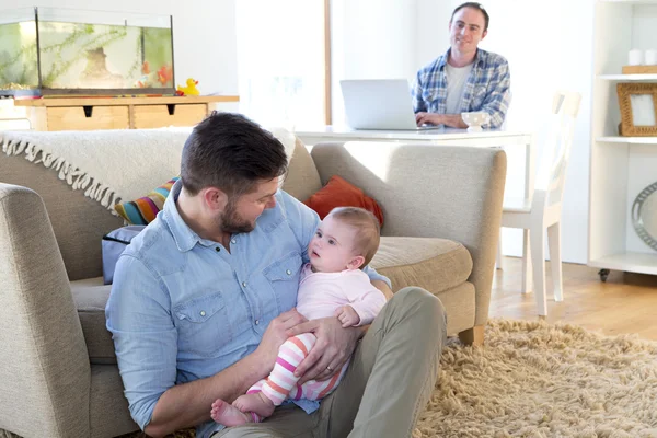 Pareja masculina en su casa con su hija bebé — Foto de Stock