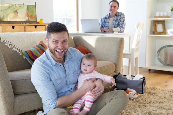 Mannelijke paar in hun huis poseren met baby dochter — Stockfoto