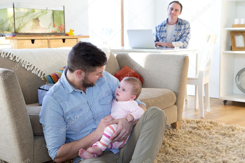 Male couple in their home with baby daughter
