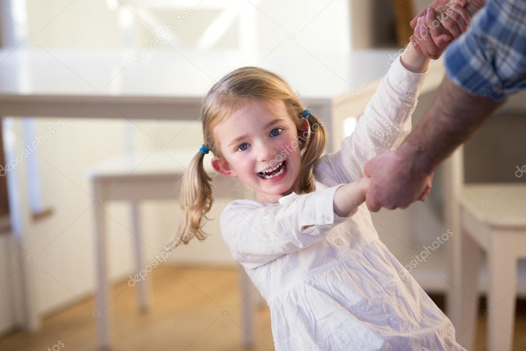 Little girl playing with father at home