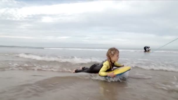 Jong meisje lichaam aan boord op het strand — Stockvideo