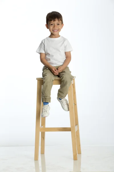 Little boy sitting on a high stool — Stock Photo, Image