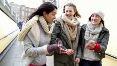 Üç kadın birlikte yürürken bir smartphone vasıl arıyor