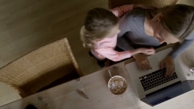 Meraklı kızı ile dizüstü bilgisayar kullanan kadın