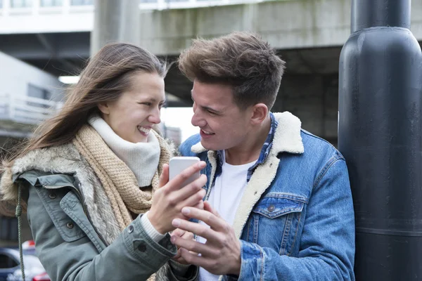 Пара смотрит на смартфон в городе — стоковое фото