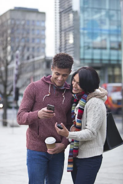 Casal na cidade olhando para um smartphone — Fotografia de Stock