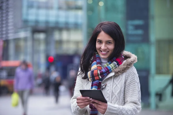 Ung kvinna i staden med en smartphone — Stockfoto