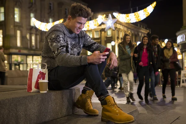 Ung mand ved hjælp af en smartphone i byen - Stock-foto