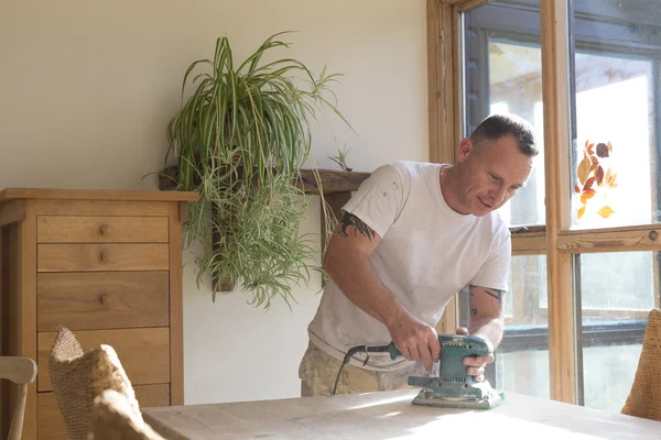 Joiner using a sander on a table surface — Stock Photo, Image