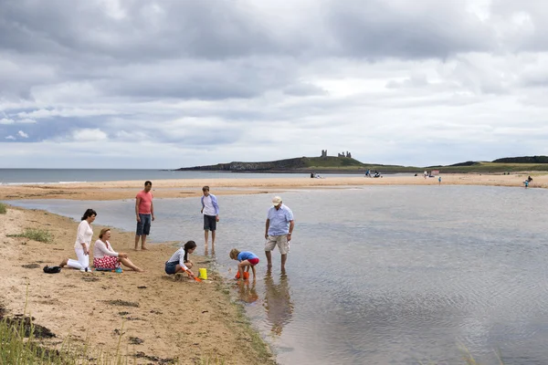 Família brincando na praia — Fotografia de Stock