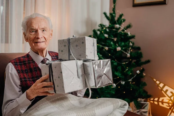 Homem Sênior Segurando Presente de Natal em Mãos no Natal — Fotografia de Stock