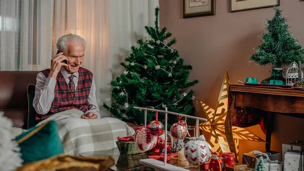 Літній старший чоловік розмовляє на мобільному на Різдвяні свята — стокове фото