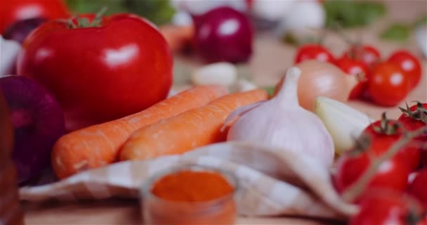 Sluiten van diverse groenten op tafel draaien. Verse tomaat, wortel, rode ui en knoflook. — Stockvideo