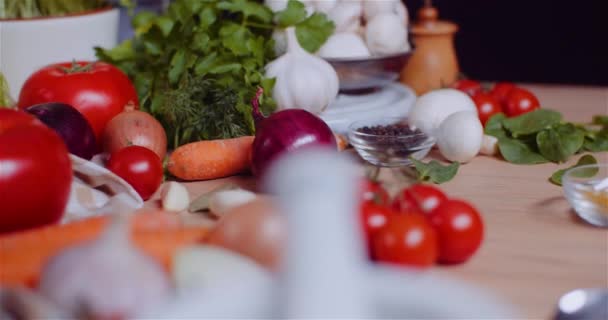 关闭各种蔬菜在桌子上旋转。新鲜番茄、胡萝卜、红葱和大蒜. — 图库视频影像