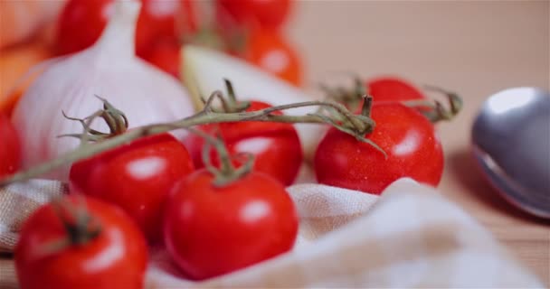 テーブルの回転で様々な野菜の閉じます。フレッシュチェリートマト、人参、赤玉ねぎ、ニンニク. — ストック動画