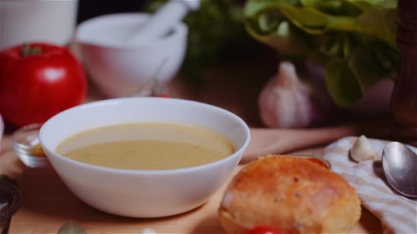 Zupa w misce wśród różnych składników Różnych posortowane na drewnianym stole — Wideo stockowe
