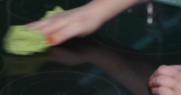 Жінка очищає електричну плиту тканиною — стокове відео