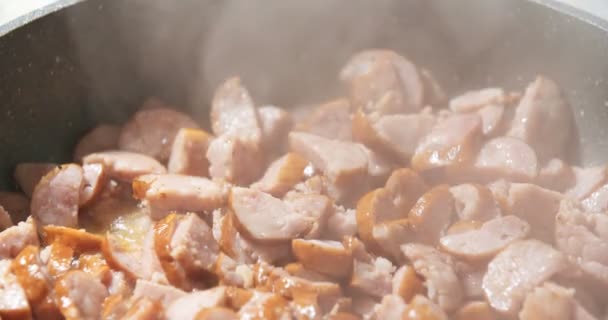Salsichas de ato de fritar na panela na cozinha — Vídeo de Stock