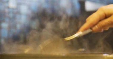 Aşçı tavada midye pişirir.